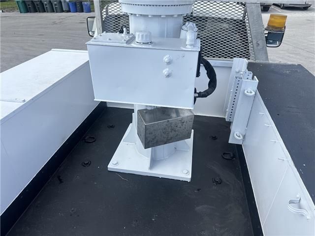 A white machine is sitting in the back of a truck.