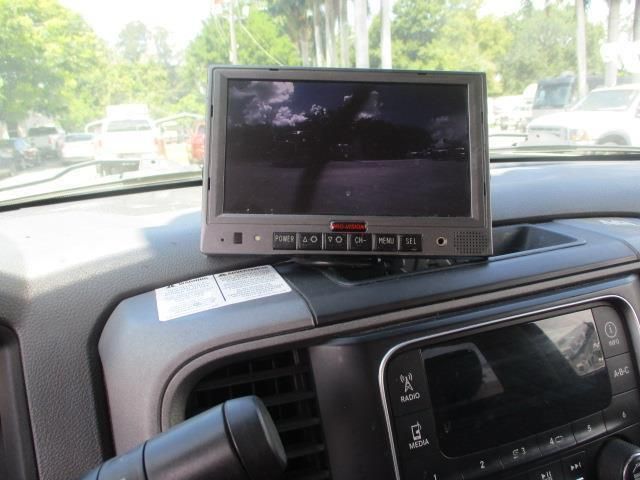 A small monitor is mounted on the dashboard of a car