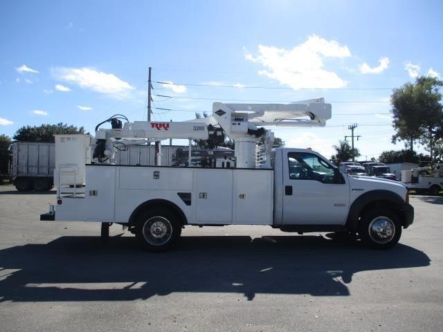 A white utility truck is parked in a parking lot