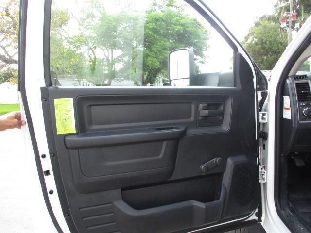 A person is opening the door of a white truck