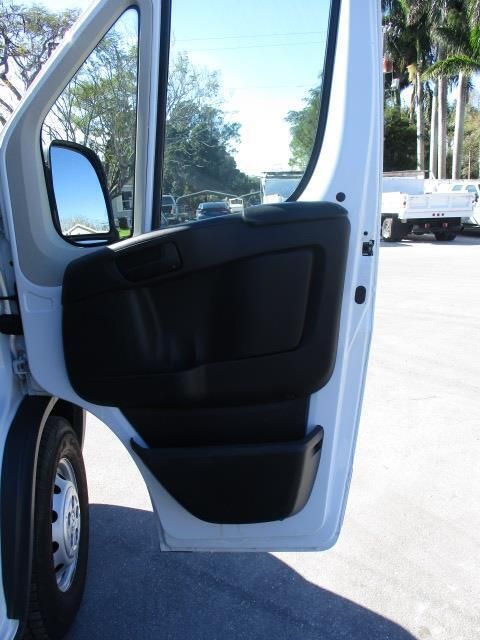 A white van with the door open is parked in a parking lot