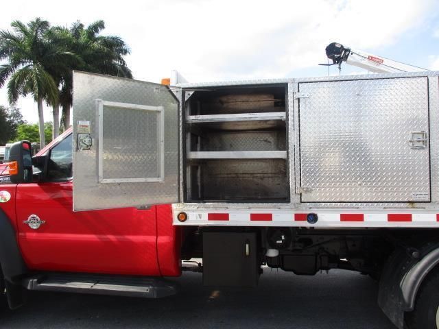 A red truck is parked with its doors open