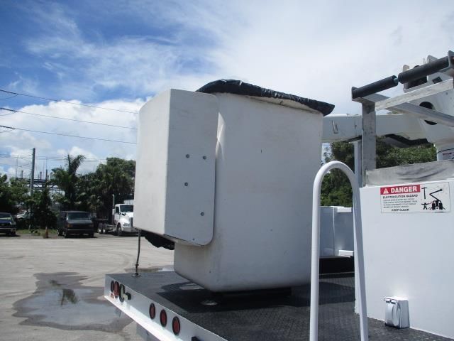 A white bucket truck with a danger sign on the side
