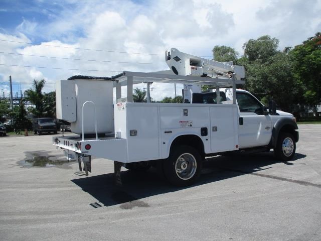 A white utility truck is parked in a parking lot