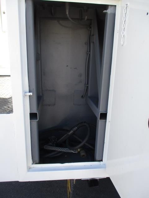 A white cabinet with the door open and a hose in it