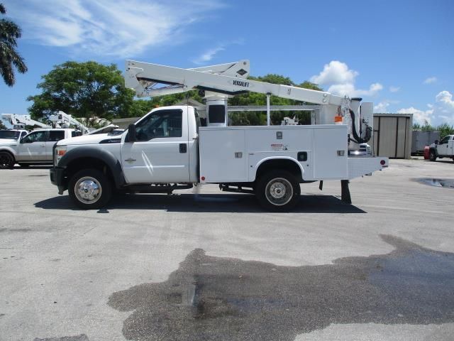 A white utility truck is parked in a parking lot
