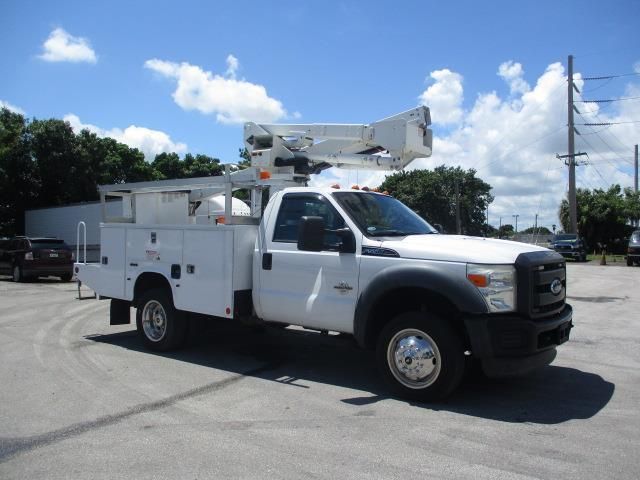 A white utility truck is parked in a parking lot