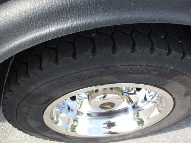 A close up of a car tire with a chrome rim