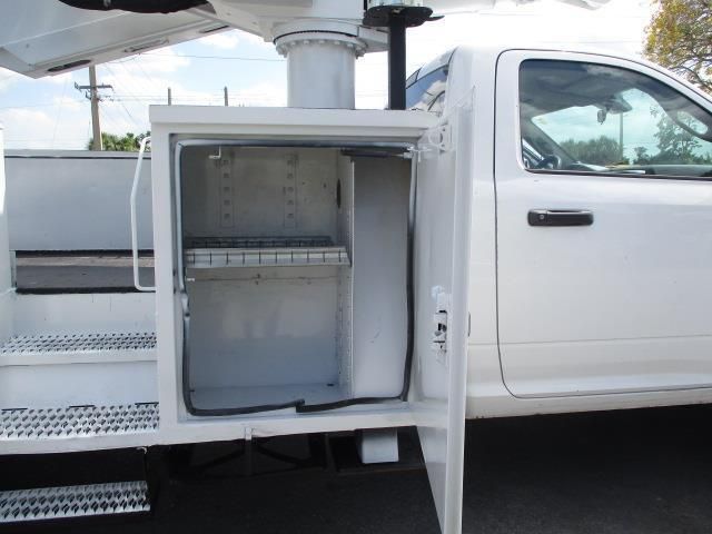 A white truck with the door open and a box in the back.