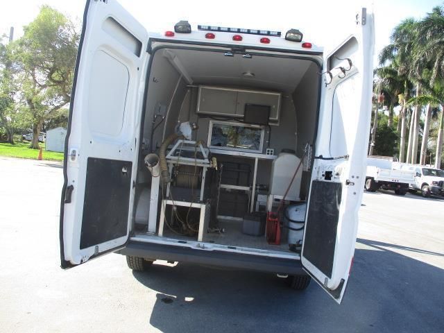 A white van is parked in a parking lot with its doors open