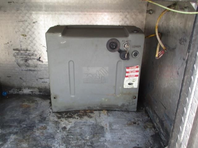 A gray box is sitting on the floor next to a wall.