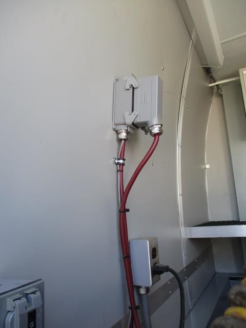 A white wall with red wires coming out of it