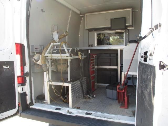 The back of a white van with a lot of equipment in it