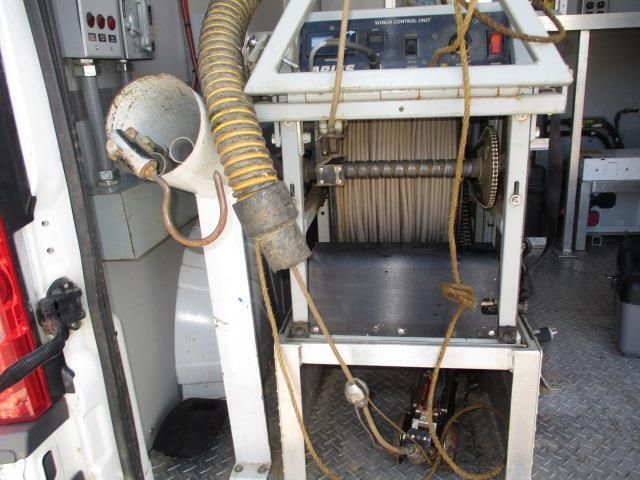 A machine with a hose attached to it is in the back of a van