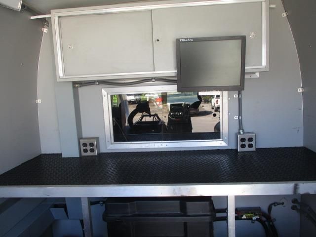 The inside of a van with a desk and a monitor