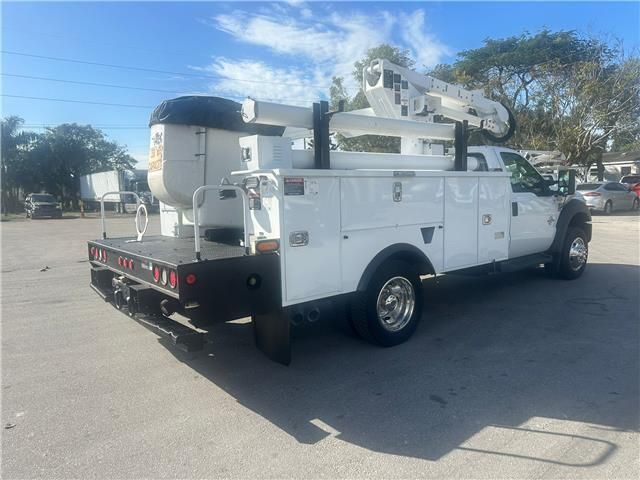 A white utility truck is parked in a parking lot.