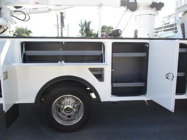 A white utility truck with the doors open