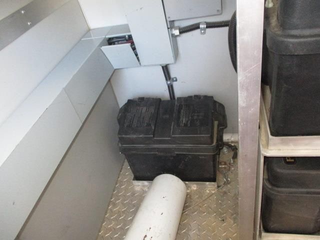 A black box is sitting on the floor next to a white pipe