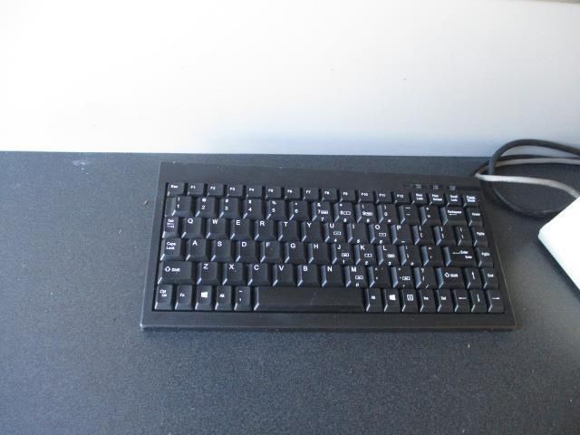 A black keyboard is sitting on a black table