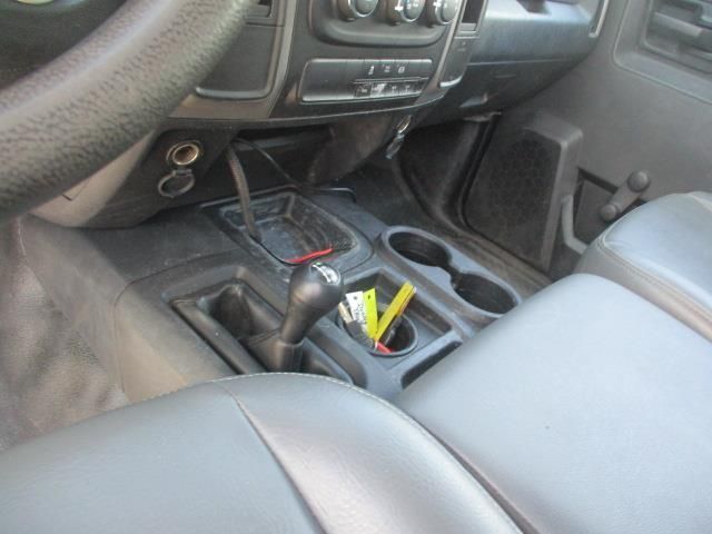 The inside of a car with a pencil in the center console.