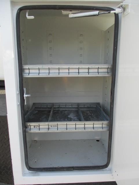 A white cabinet with a glass door and shelves