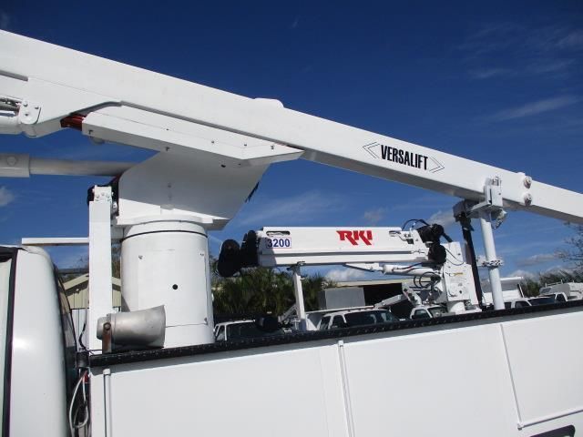 A versalift crane is attached to the back of a white truck