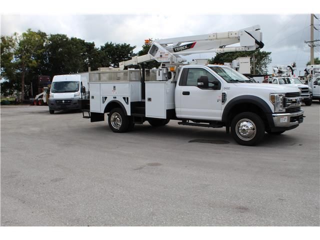 A white utility truck is parked in a parking lot
