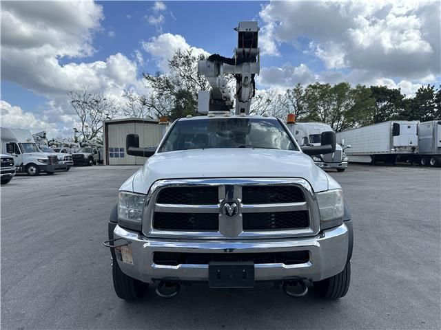 A white truck with a crane on top of it is parked in a parking lot.