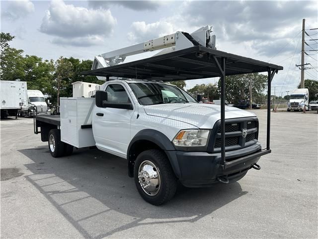 A white truck with a canopy on top of it is parked in a parking lot.