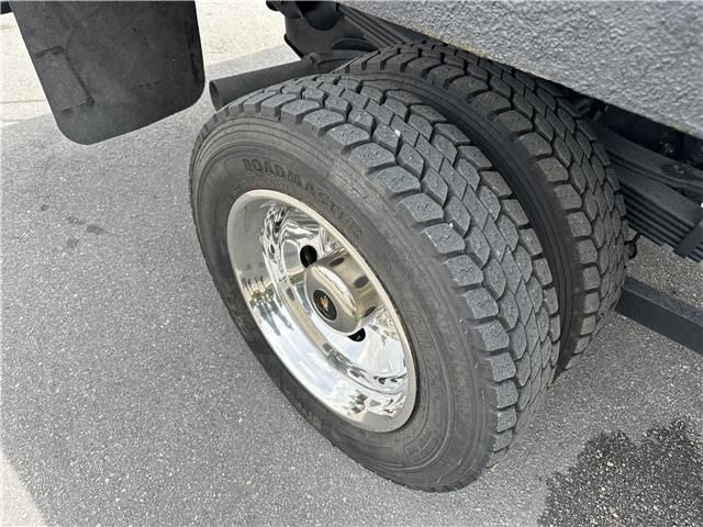A close up of a truck tire on a road.