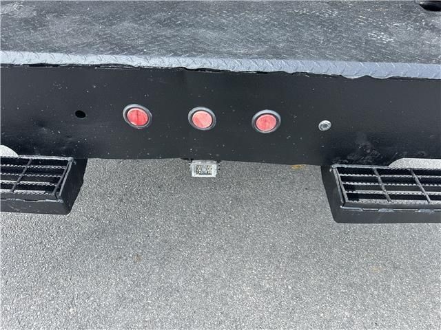 The back of a truck with three red lights on it.