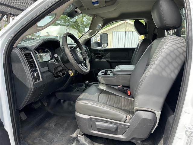 The interior of a white truck with black seats and a steering wheel.