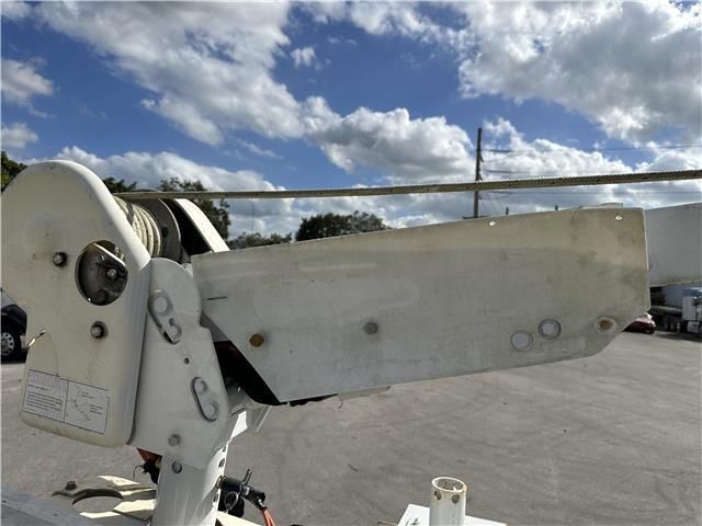 A white vehicle is parked in a parking lot with a blue sky in the background