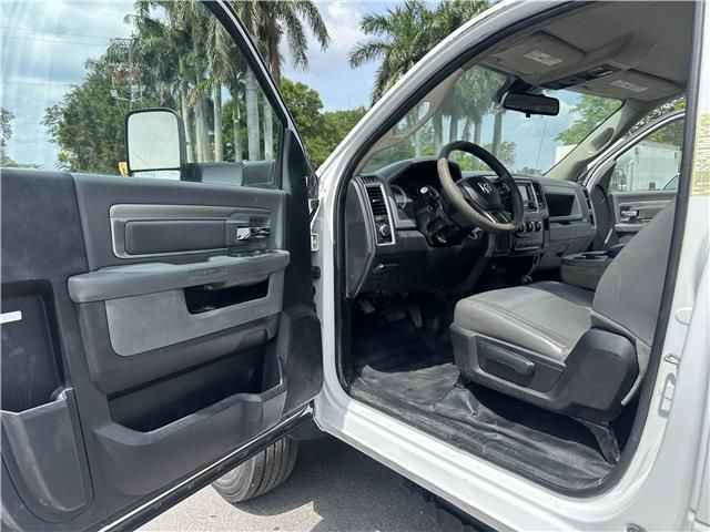 The inside of a white truck with the door open and the steering wheel visible.