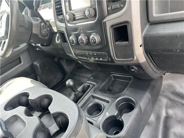 The interior of a dodge ram truck with cup holders and a steering wheel.