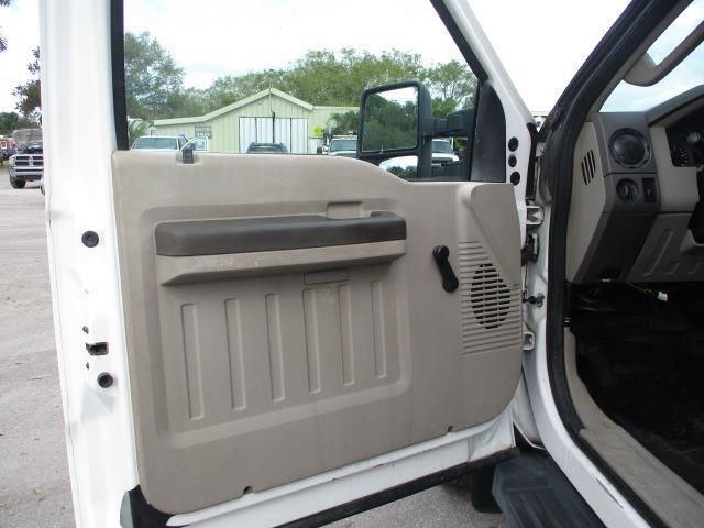 A white truck is parked in a parking lot with the door open