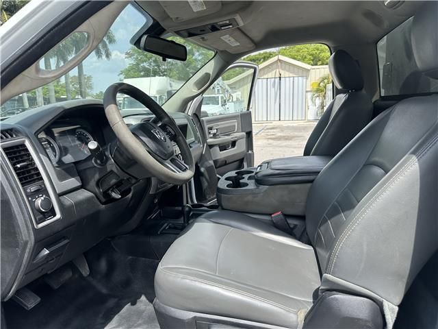 The interior of a white truck with black seats and a steering wheel.