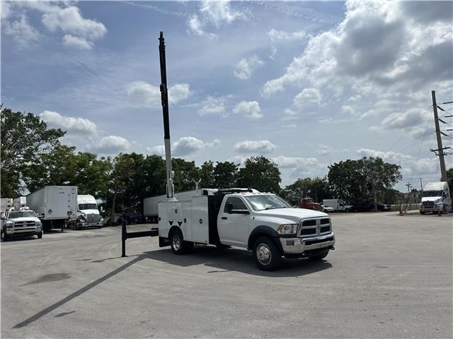A white utility truck is parked in a parking lot