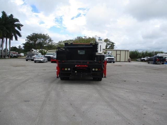 A black dump truck is parked in a parking lot