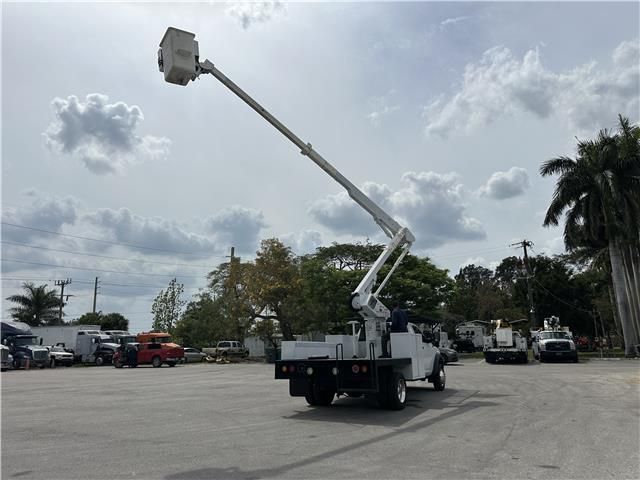 A truck with a bucket on top of it is parked in a parking lot