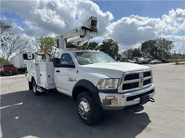 A white utility truck with a crane on top of it is parked in a parking lot.