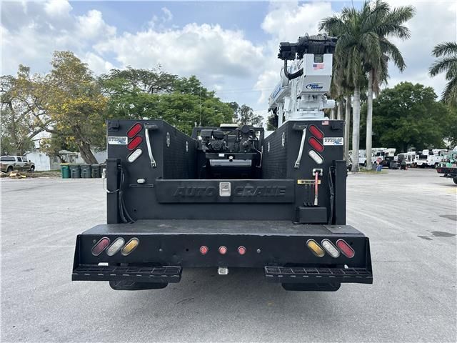 A utility truck is parked in a parking lot with palm trees in the background