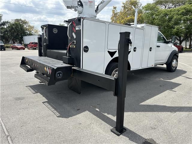 A white utility truck is parked in a parking lot.