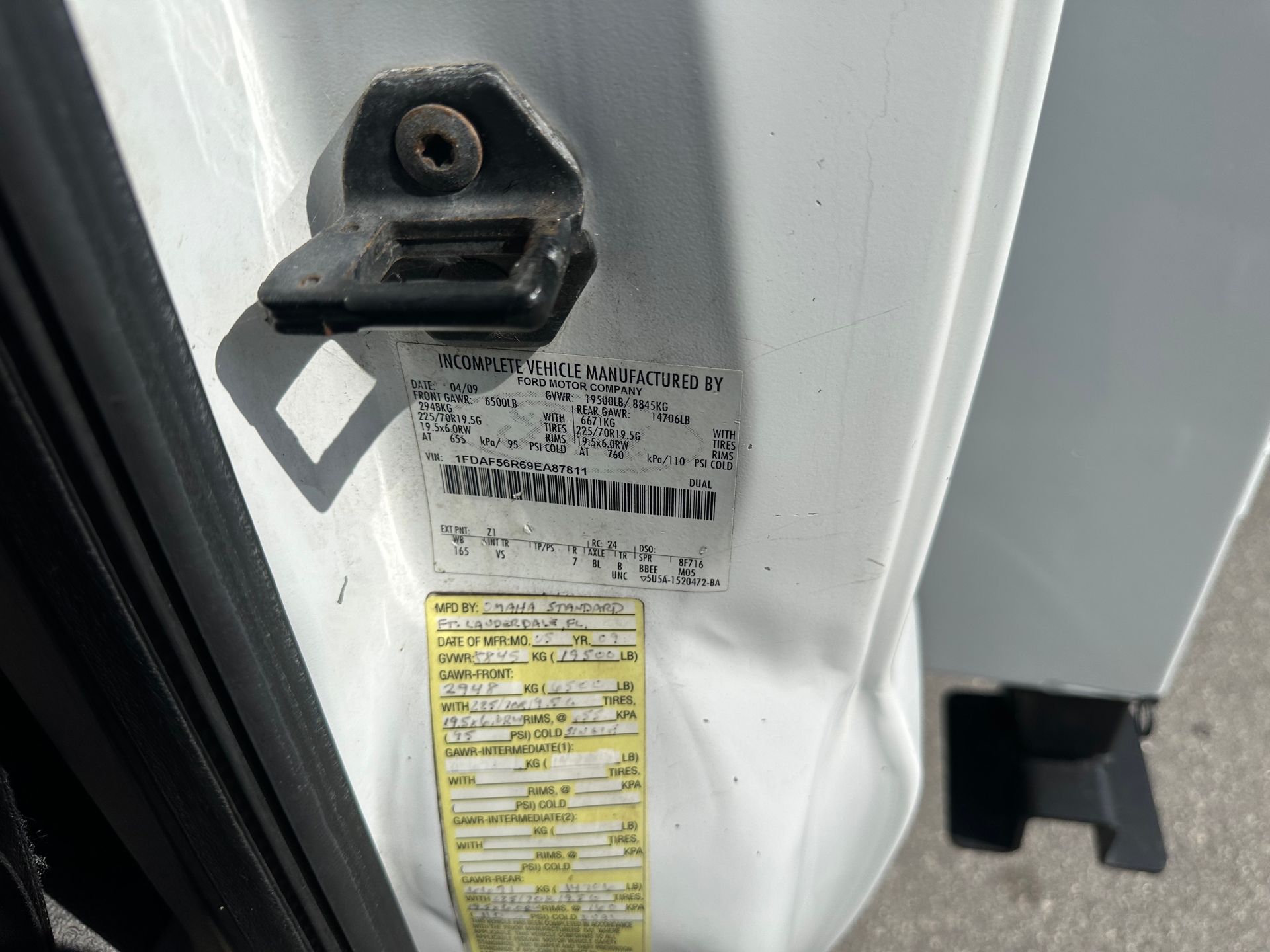 A close up of a white car with a sticker on the side of it.