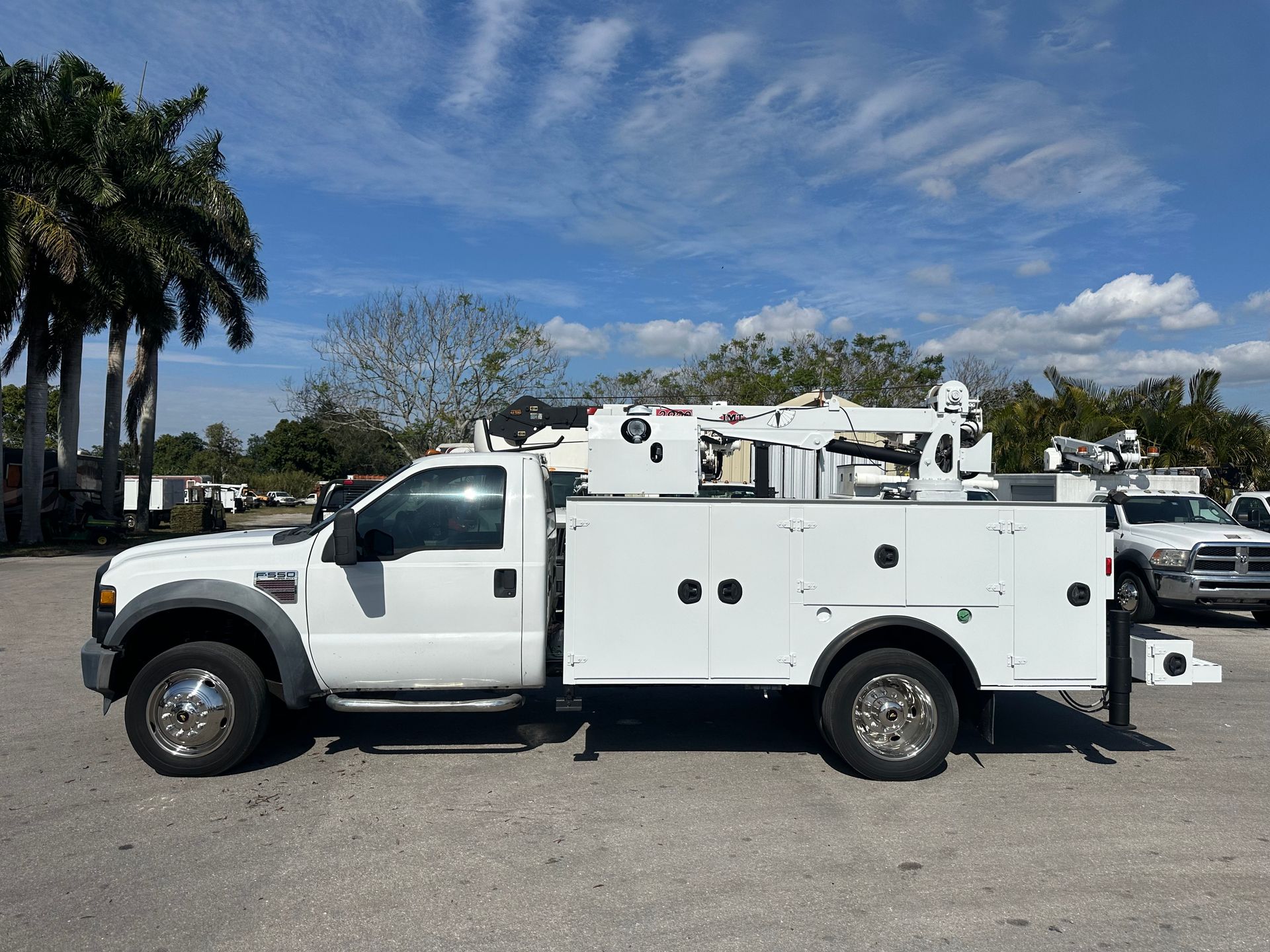 A white utility truck is parked in a parking lot.