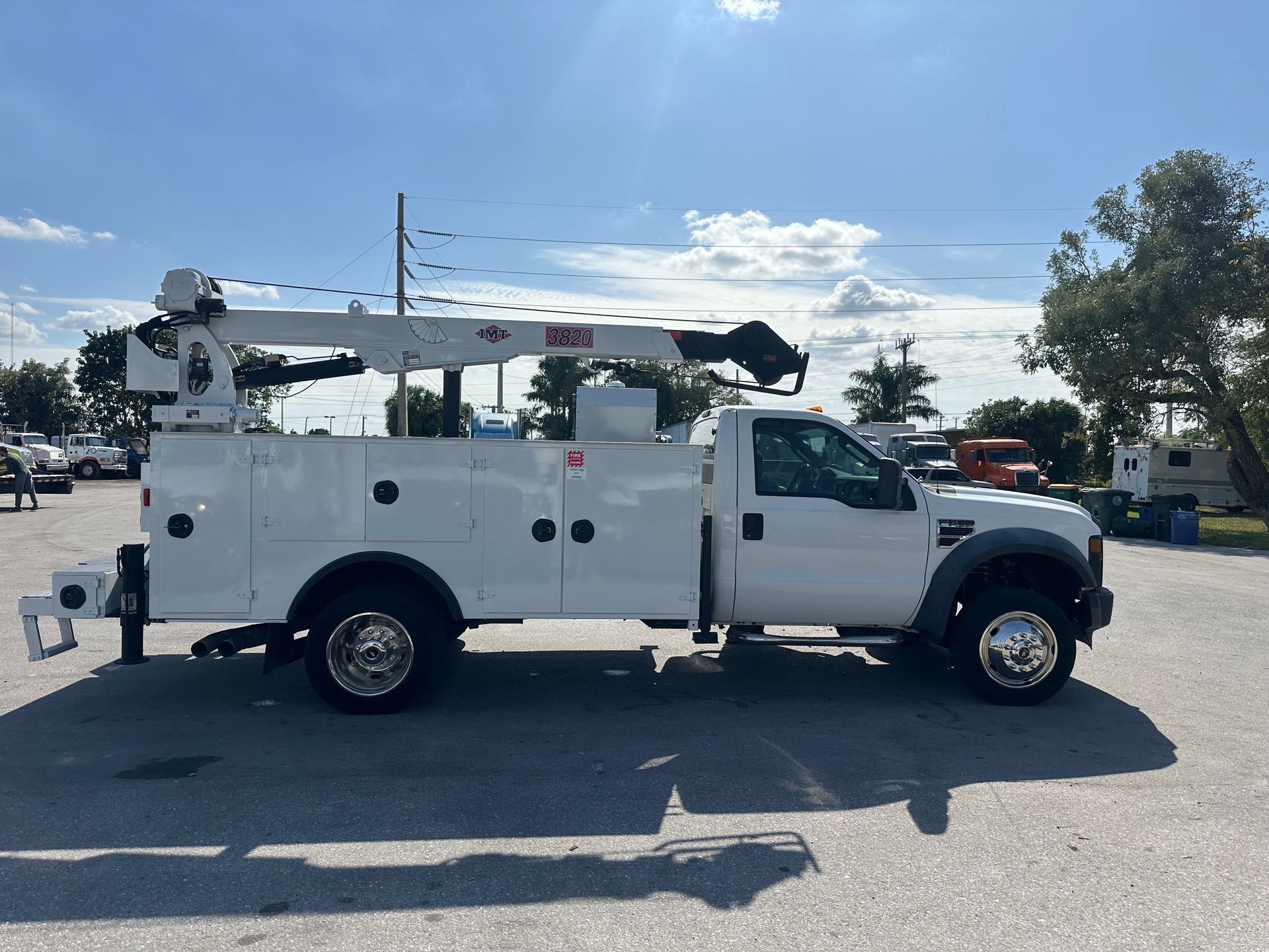 A white utility truck is parked in a parking lot.