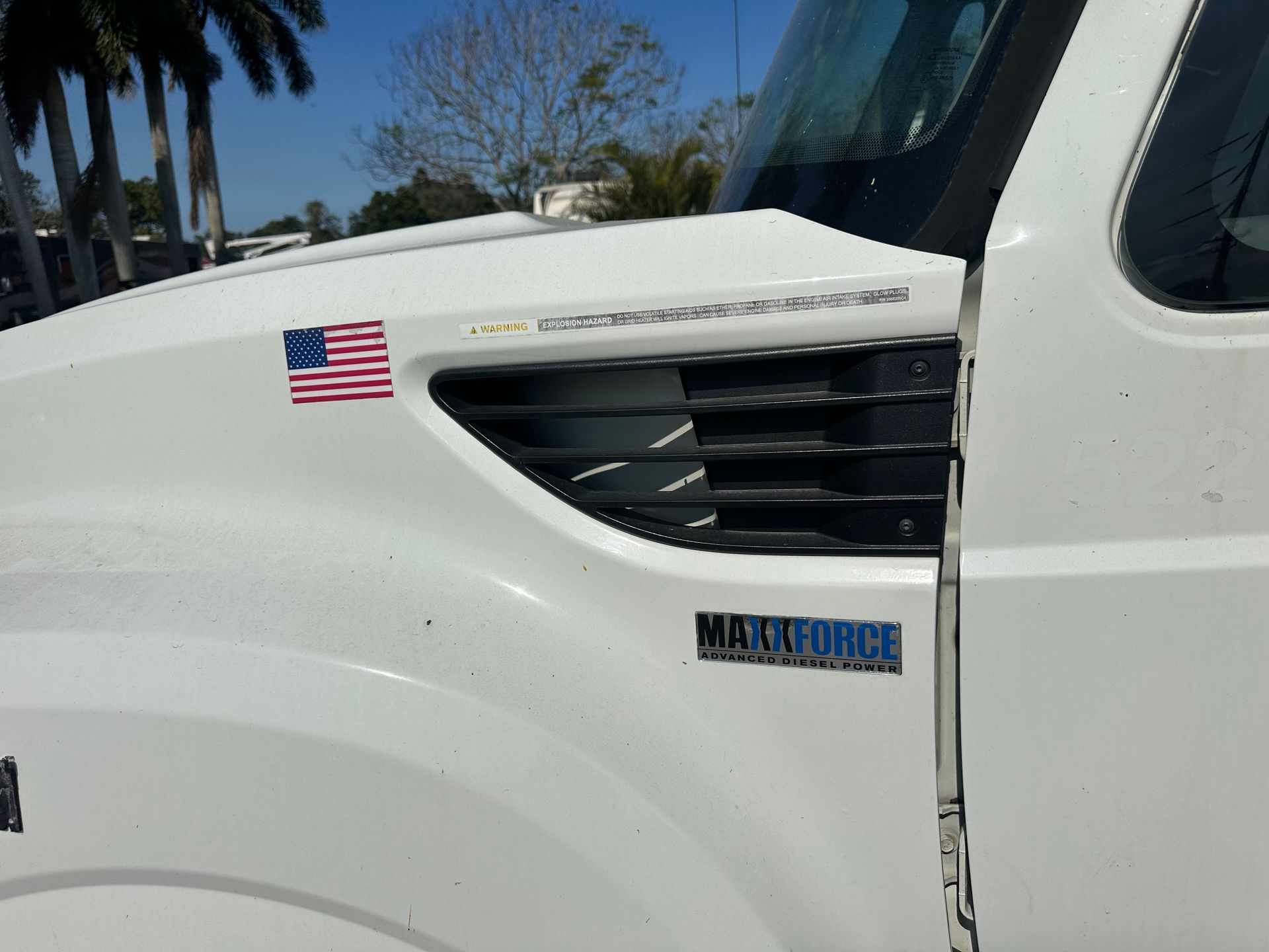 A white truck with an american flag on the hood
