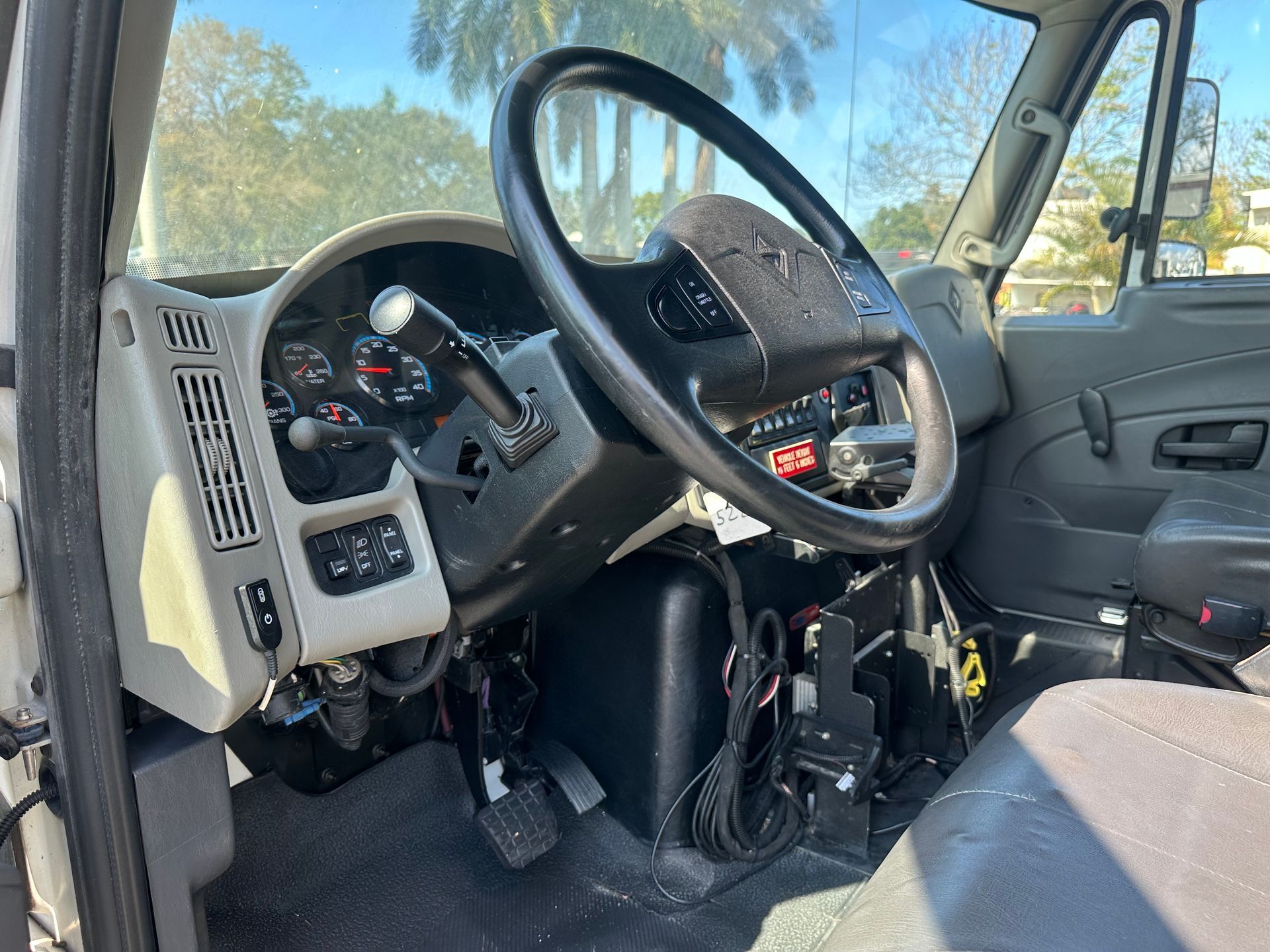 The inside of a truck with a steering wheel and dashboard.