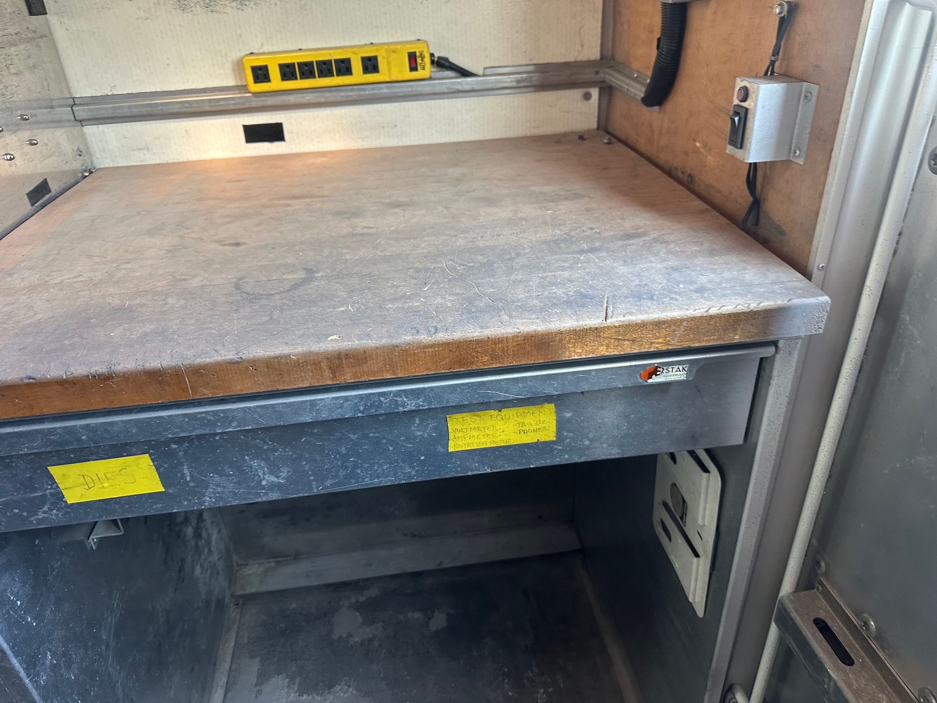 A yellow power plug is sitting on top of a wooden base.