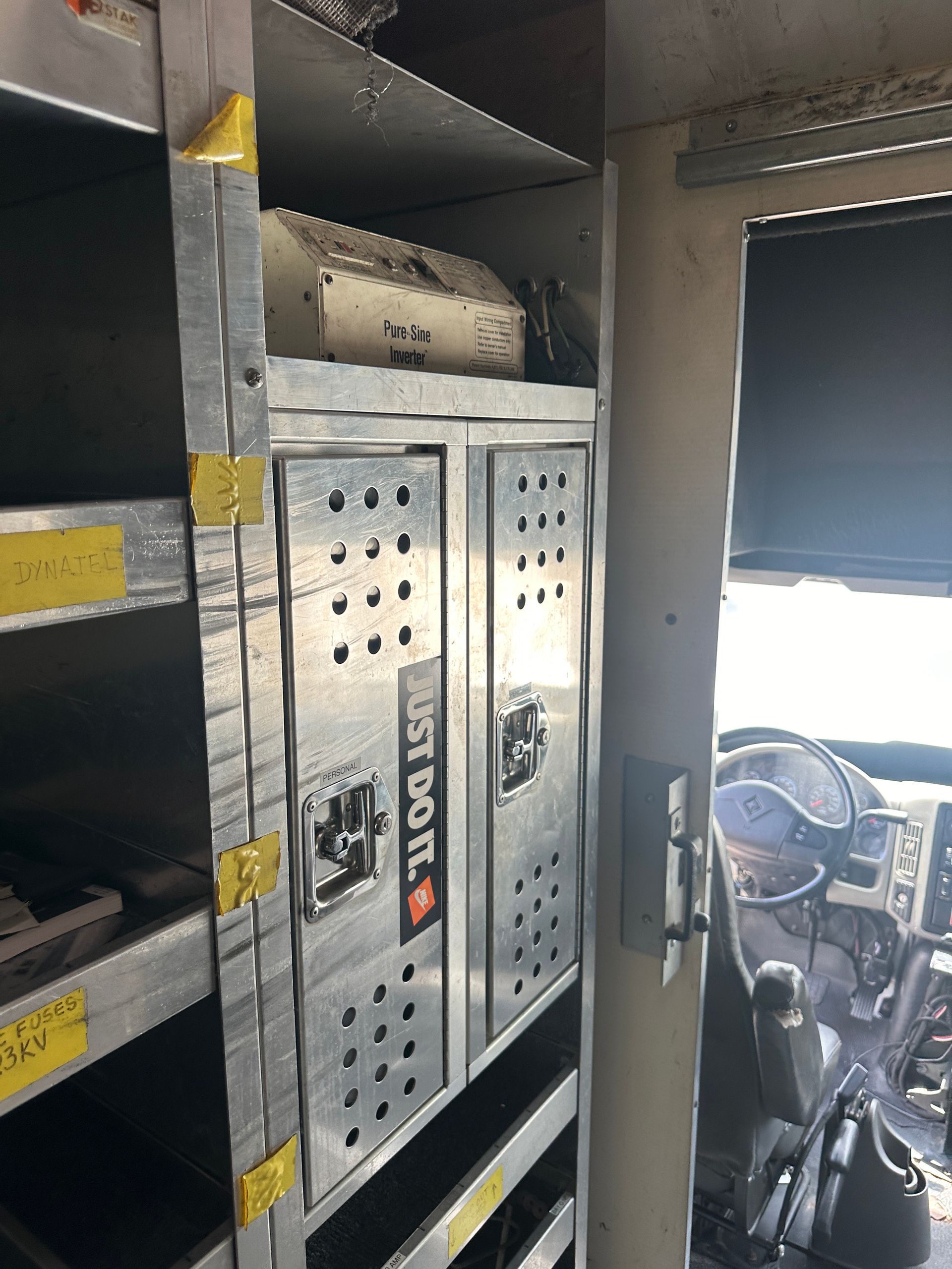 The inside of a truck with shelves and lockers that say just do it